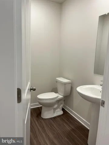 a white toilet sitting next to a white sink and vanity