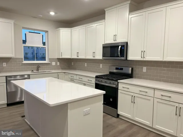 a kitchen with stainless steel appliances granite countertop a sink stove and microwave