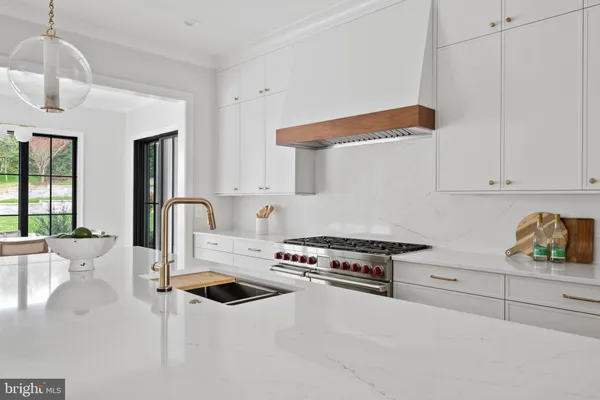 a kitchen with white cabinets appliances and sink