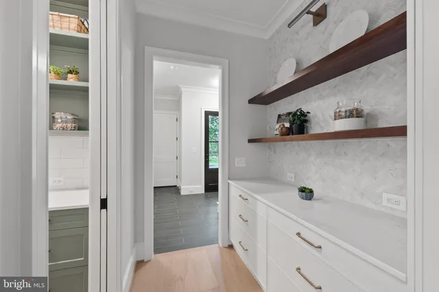 a kitchen with white cabinets and window