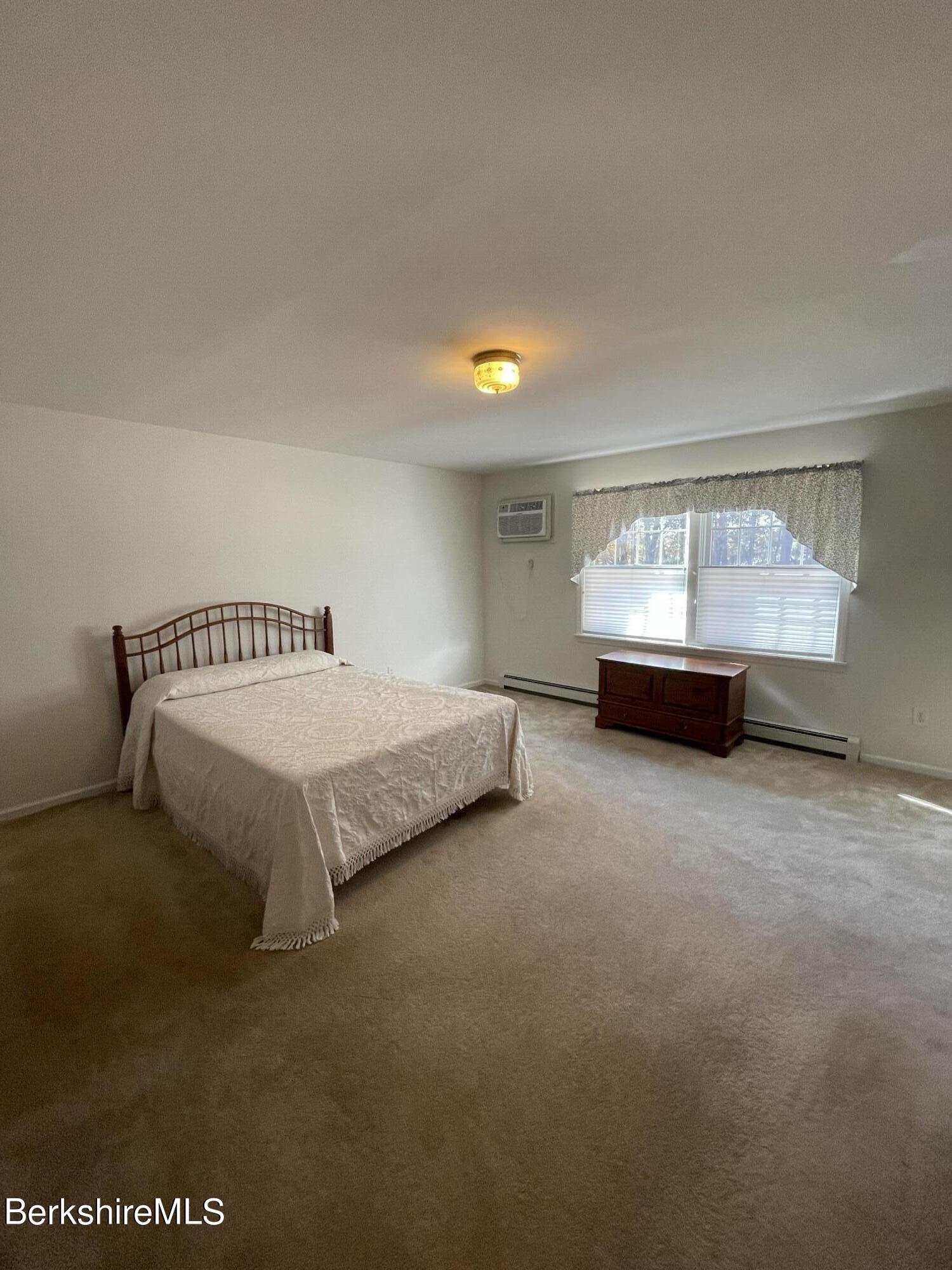 181 Main Road Monterey, MA 01230 - Photo 16 of 63 a spacious bedroom with a bed and window