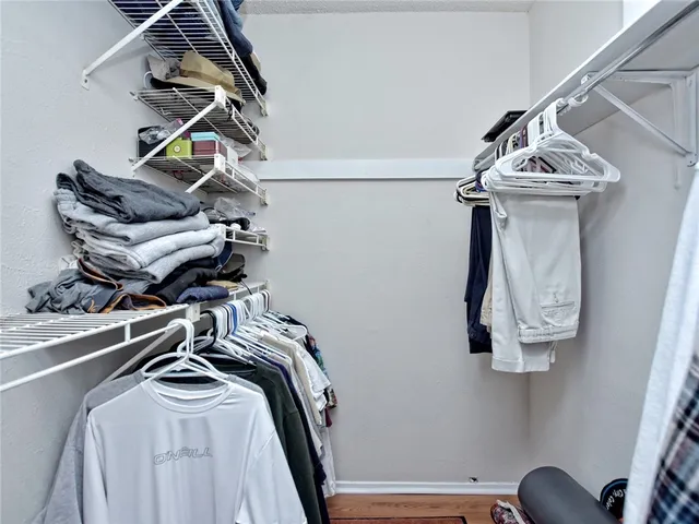 a view of walk in closet with clothes and shoes