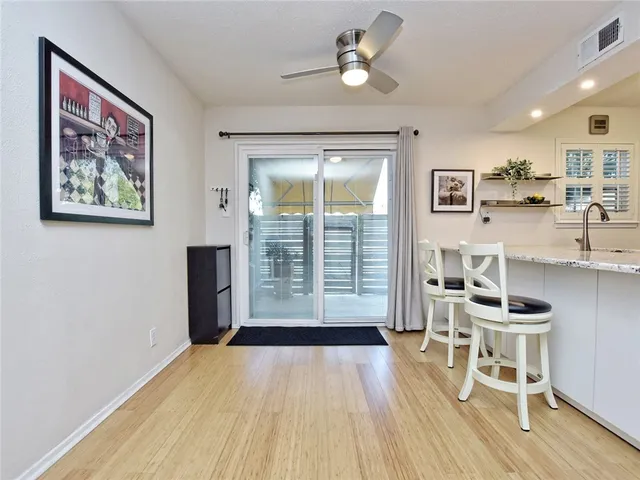 a view of a livingroom with furniture wooden floor and a ceiling fan