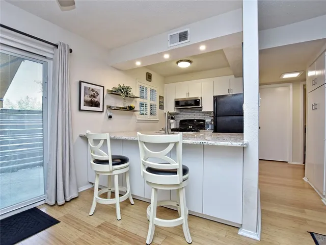 a kitchen with cabinets and chairs in it
