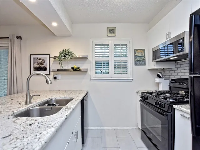 a kitchen with stainless steel appliances granite countertop a sink stove and cabinets