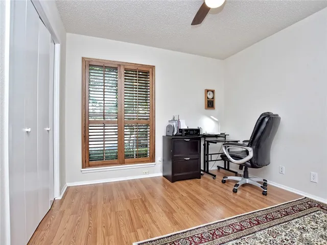 a view of a workspace with furniture and a window