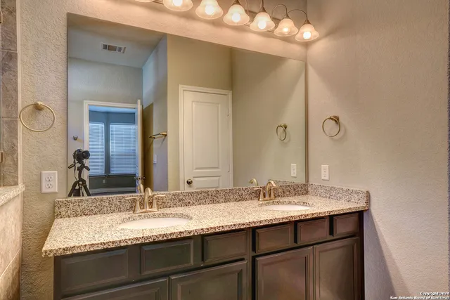 a bathroom with a granite countertop sink and a mirror