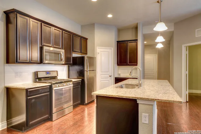 a kitchen with stainless steel appliances granite countertop a sink stove and refrigerator