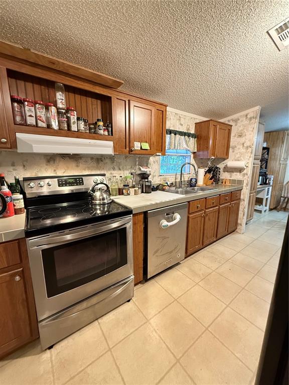 5109 Southwest 10th Street Bell, FL 32619 - Photo 23 of 38 a kitchen with a stove top oven cabinets and stainless steel appliances