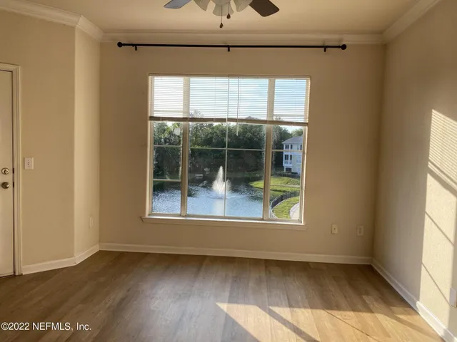 a view of a big room with wooden floor and windows