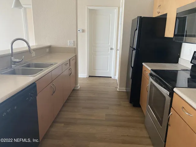 a kitchen with a refrigerator and a sink