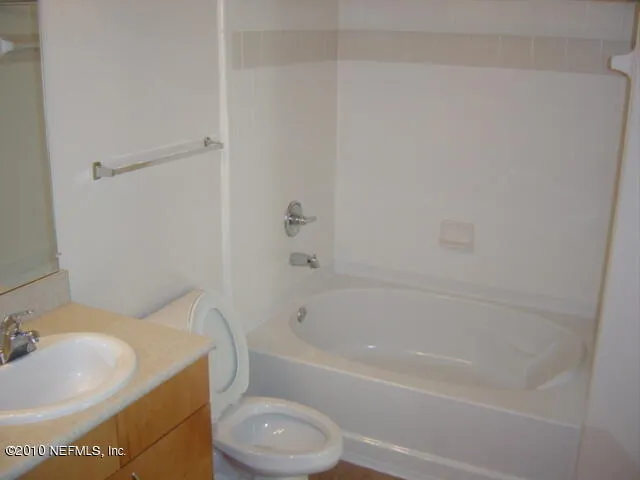 a bath room with a toilet a sink and a bath tub