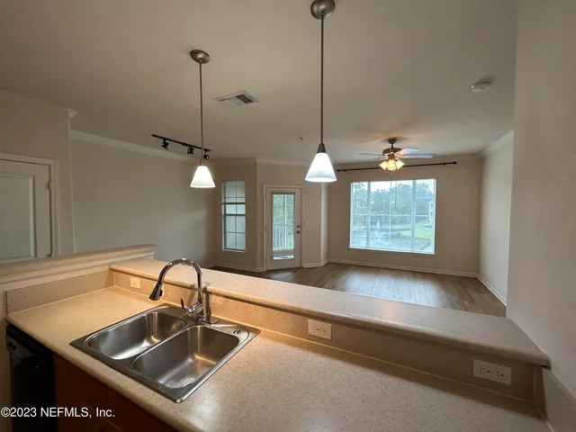 a kitchen with a sink a counter and windows