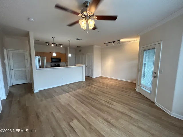 a view of a big room with wooden floor and a ceiling fan