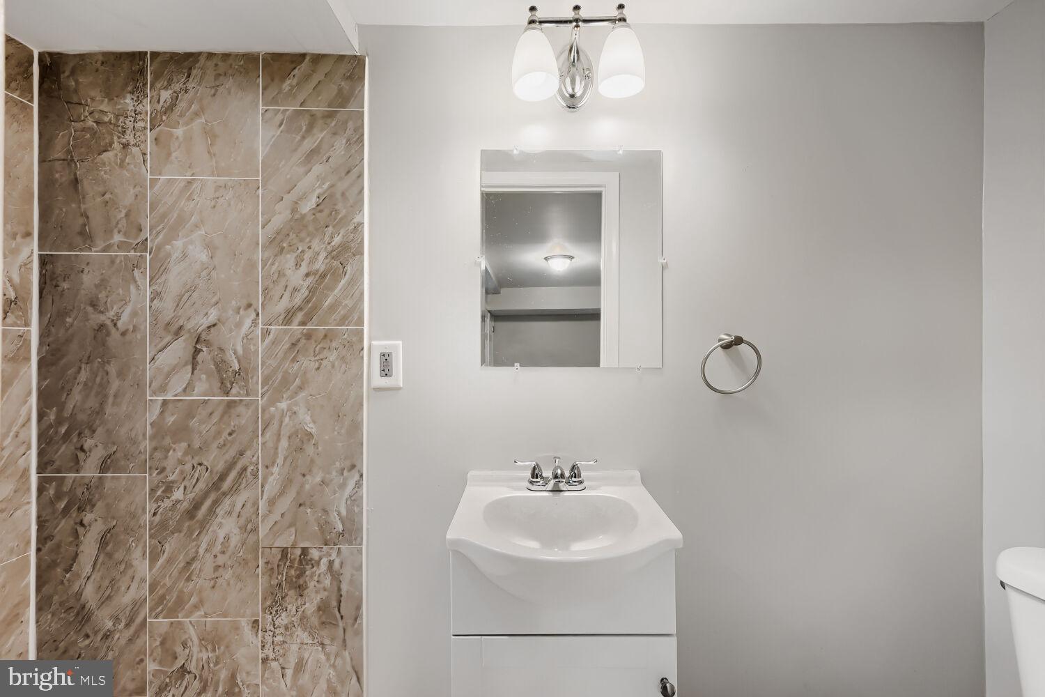 1014 Lyndhurst Street Baltimore, MD 21229 - Photo 24 of 29 a bathroom with a sink a mirror and shower