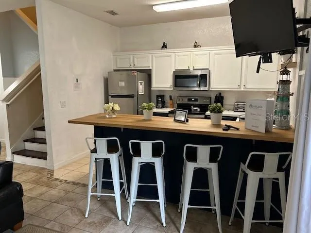 a kitchen with a dining table chairs and a refrigerator