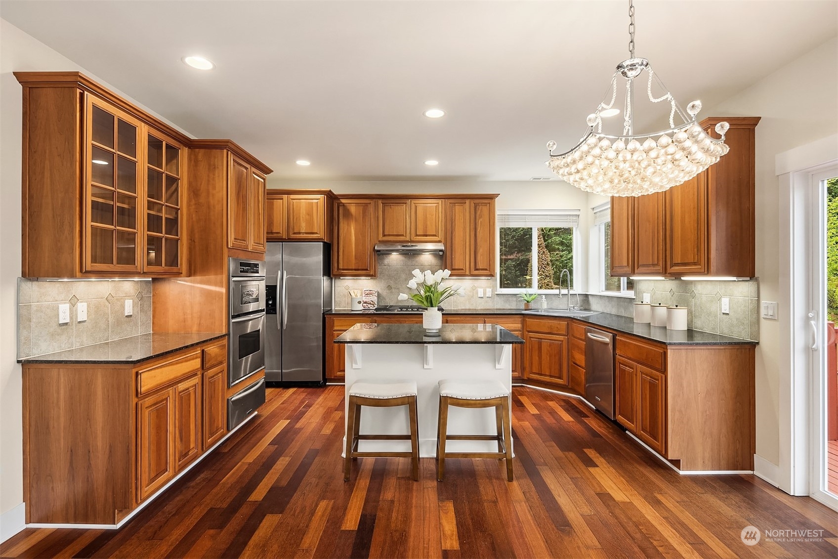 5004 Northeast 25th Street Renton, WA 98059 - Photo 14 of 37 a kitchen with stainless steel appliances granite countertop a refrigerator a sink dishwasher a dining table and chairs with wooden floor