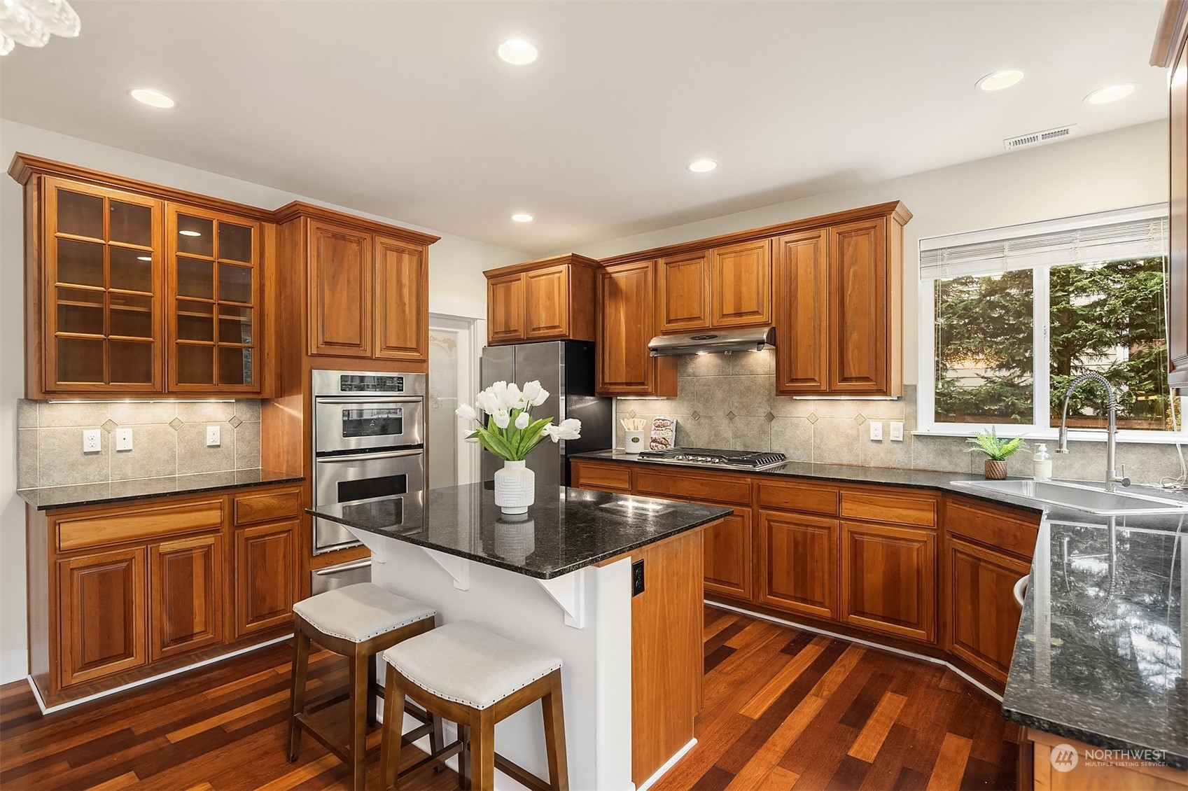 5004 Northeast 25th Street Renton, WA 98059 - Photo 17 of 37 a kitchen with stainless steel appliances granite countertop a stove top oven a sink dishwasher and cabinets with wooden floor