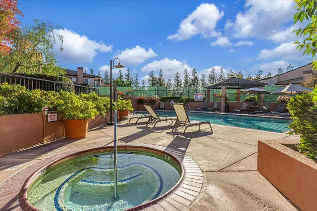 a swimming pool with outdoor seating and plants