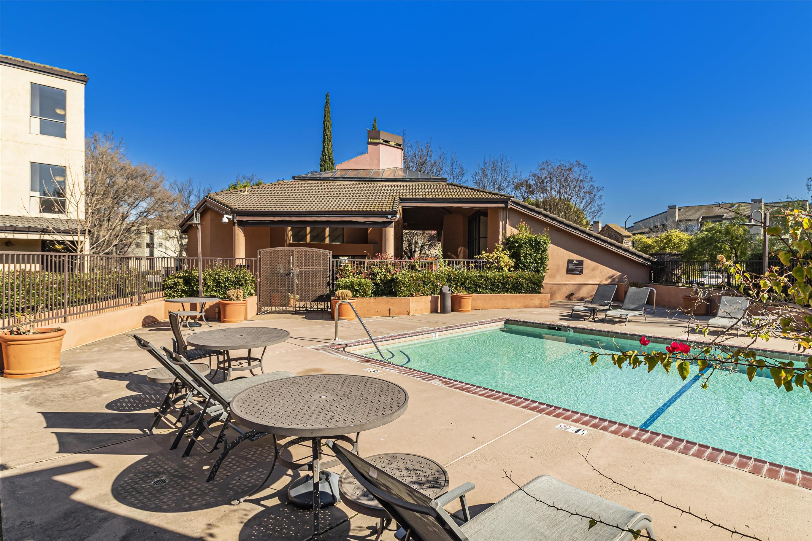 39059 Guardino Drive, Unit 206 Fremont, CA 94538 - Photo 34 of 37 a view of a patio with couches table and chairs under an umbrella with a barbeque