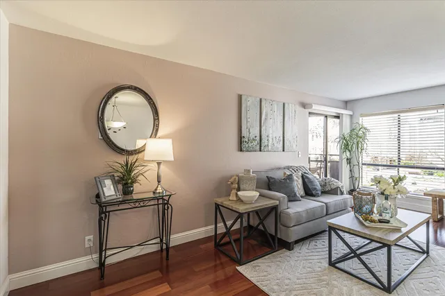 a living room with furniture a rug a lamp and a window