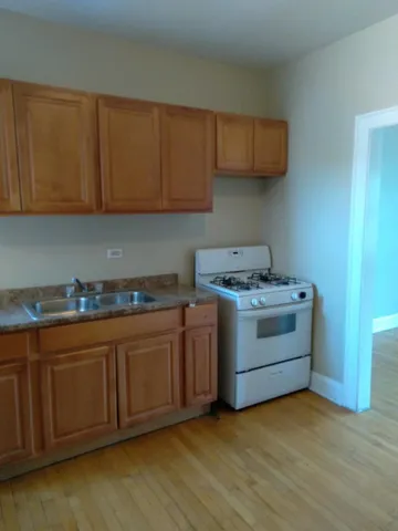 a kitchen with granite countertop a sink cabinets and stainless steel appliances
