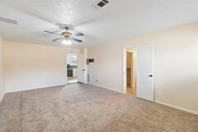 a view of a big room with chandelier fan and windows