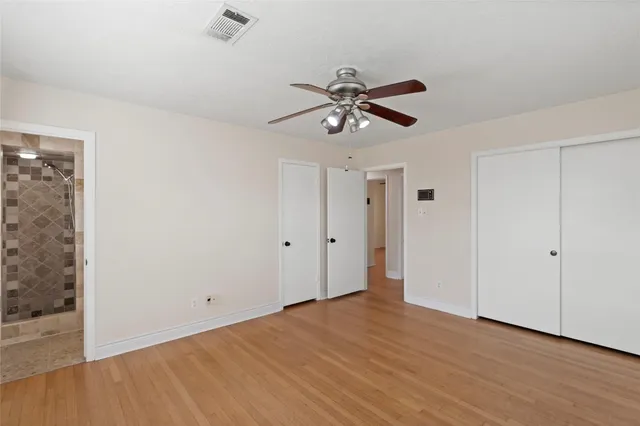 a view of room with wooden floor and ceiling fan