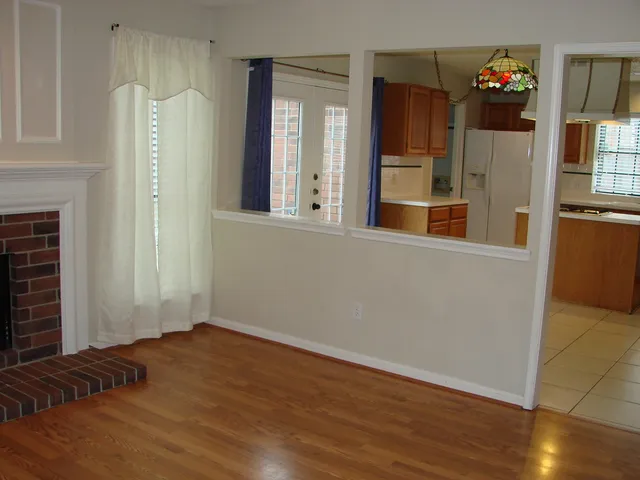 a view of a bedroom with wooden floor and windows