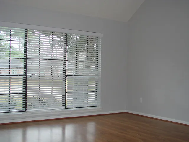 a view of a small space with wooden floor and a window