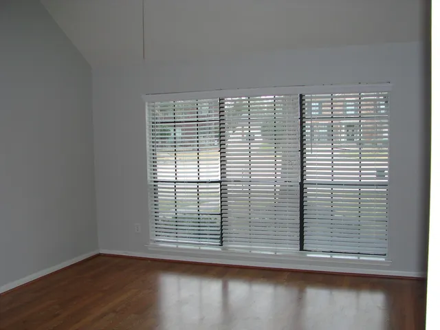 a view of a small space with wooden floor and a window