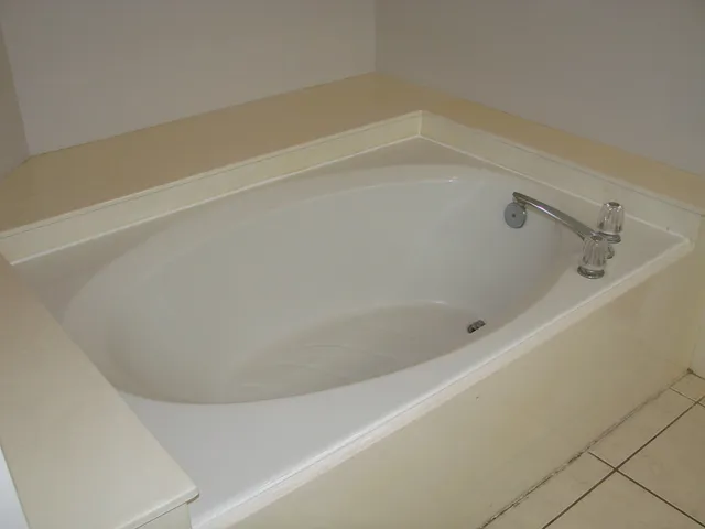 a bath tub sitting next to a white sink and vanity