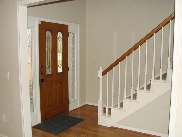 a view of a hallway with wooden floor and staircase
