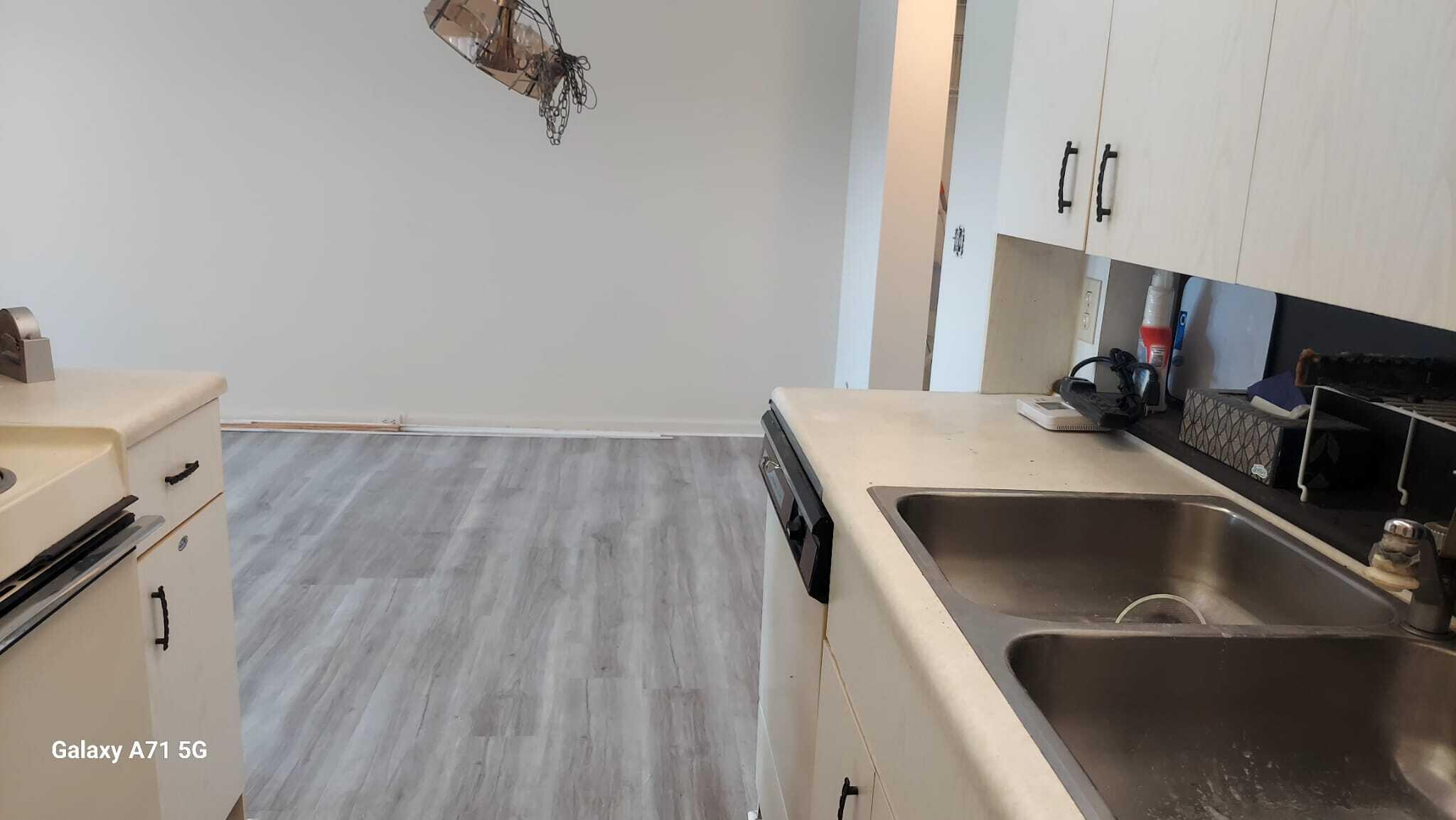 2069 Yarmouth C, Unit 2069 Boca Raton, FL 33434 - Photo 5 of 33 a kitchen with a sink and wooden floor