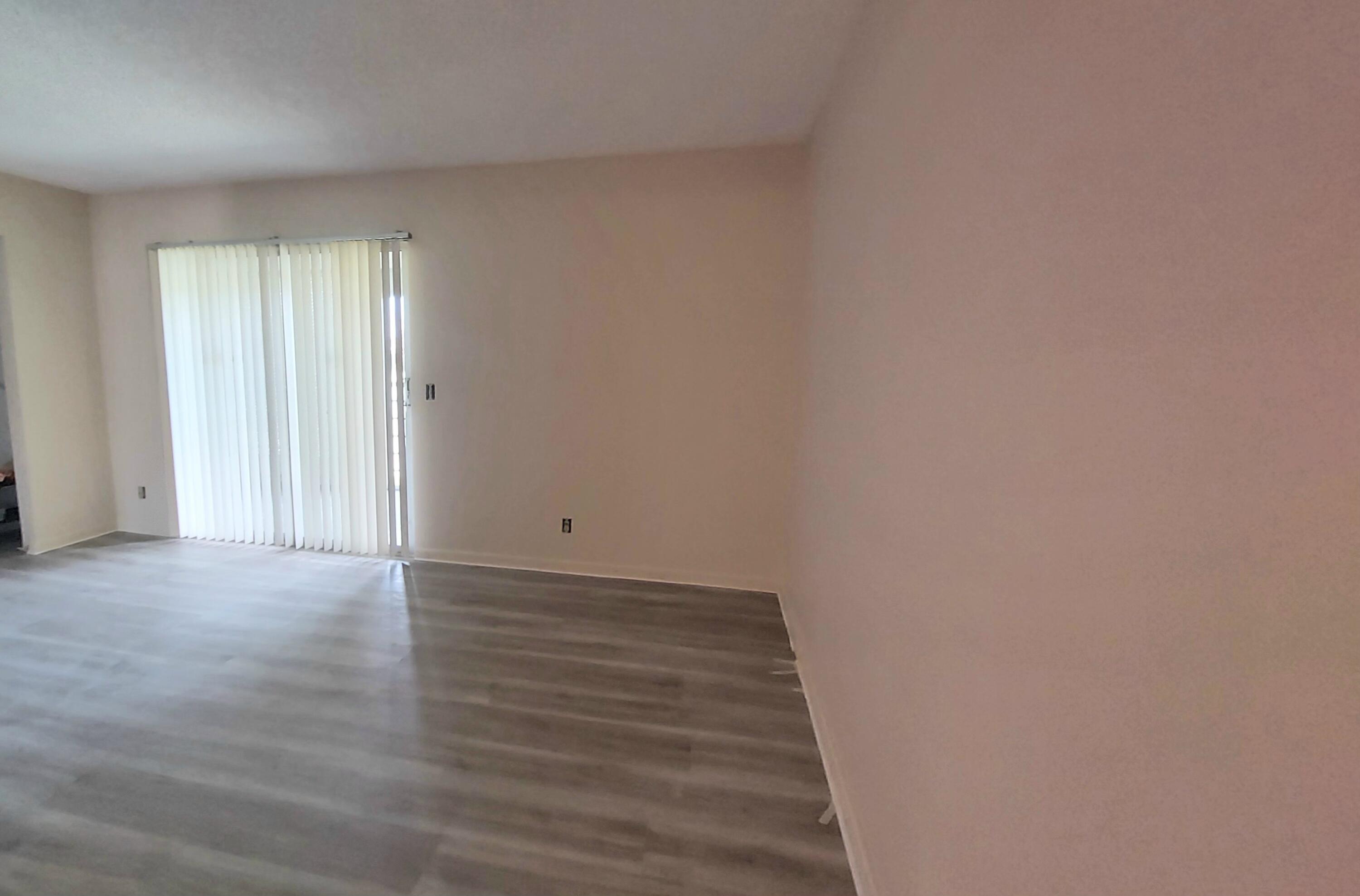 2069 Yarmouth C, Unit 2069 Boca Raton, FL 33434 - Photo 8 of 33 a view of an empty room with wooden floor