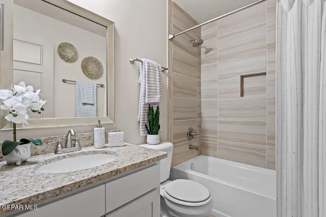 a bathroom with a granite countertop sink toilet and mirror