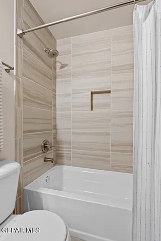a bathroom with a granite countertop sink a toilet and a mirror