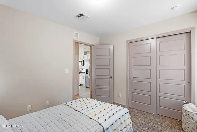 a bedroom with a bed a mirror and a window