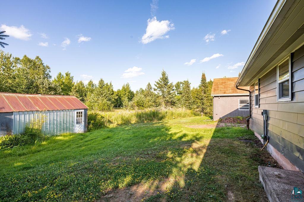 3949 East County Rd B Superior, WI 54880 - Photo 11 of 50 Expansive grassy area with a detached shed featuring a metal roof and a separate structure with horizontal siding