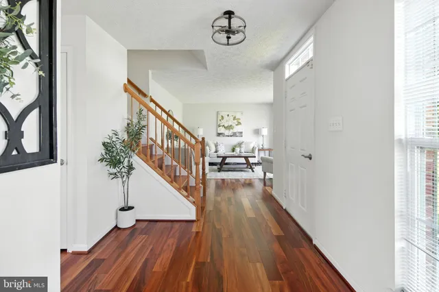 a view of a hallway with wooden floor and stairs
