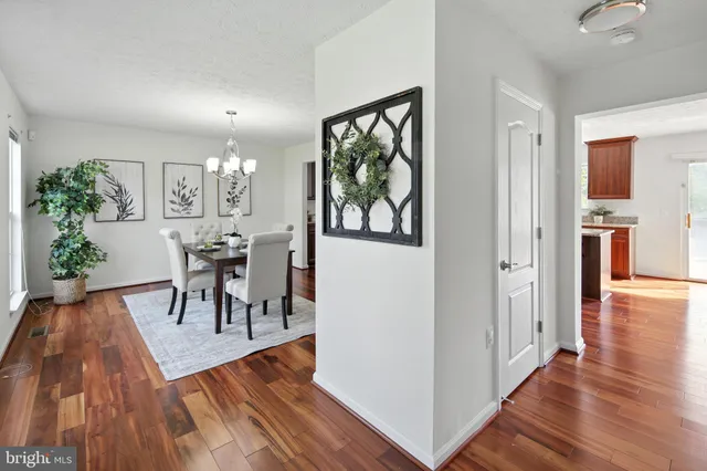 a view of a dining room with furniture a chandelier and wooden floor
