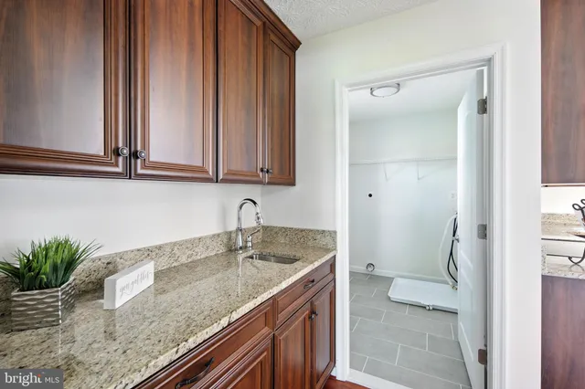 a kitchen with a granite countertop sink and white cabinets