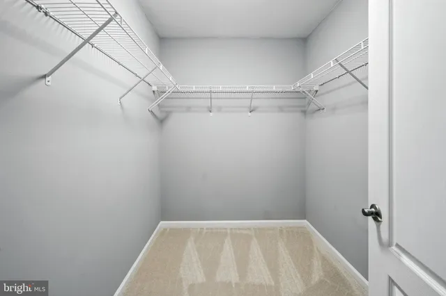 an empty room with windows and ceiling fan