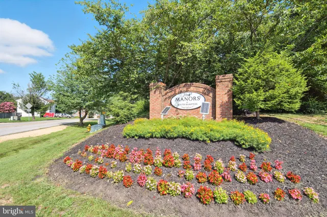 a sign that is sitting in front of flowers