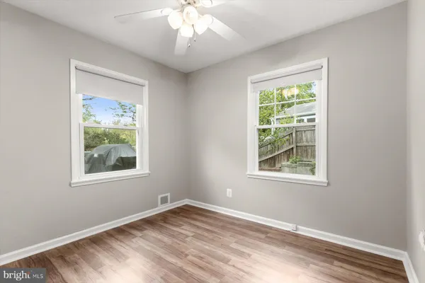 an empty room with a ceiling fan and a window