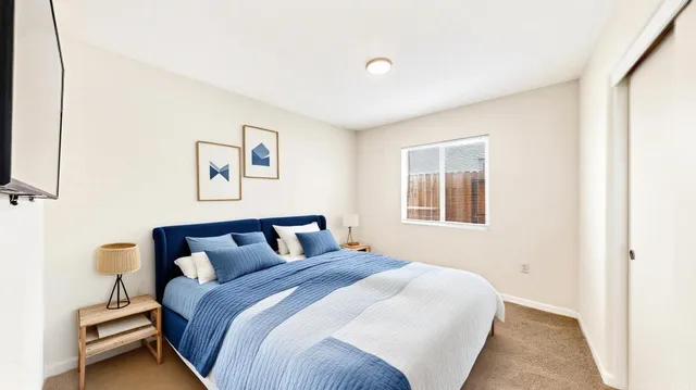 a bedroom with a bed and painting on the wall