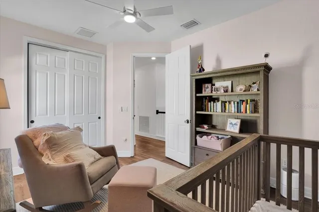 a view of a hallway to a bedroom with wooden floor and windows
