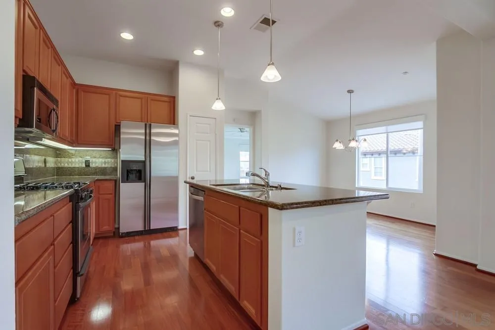 1631 Avery Road San Marcos, CA 92078 - Photo 11 of 32 a kitchen with granite countertop a sink a counter top space stainless steel appliances and cabinets