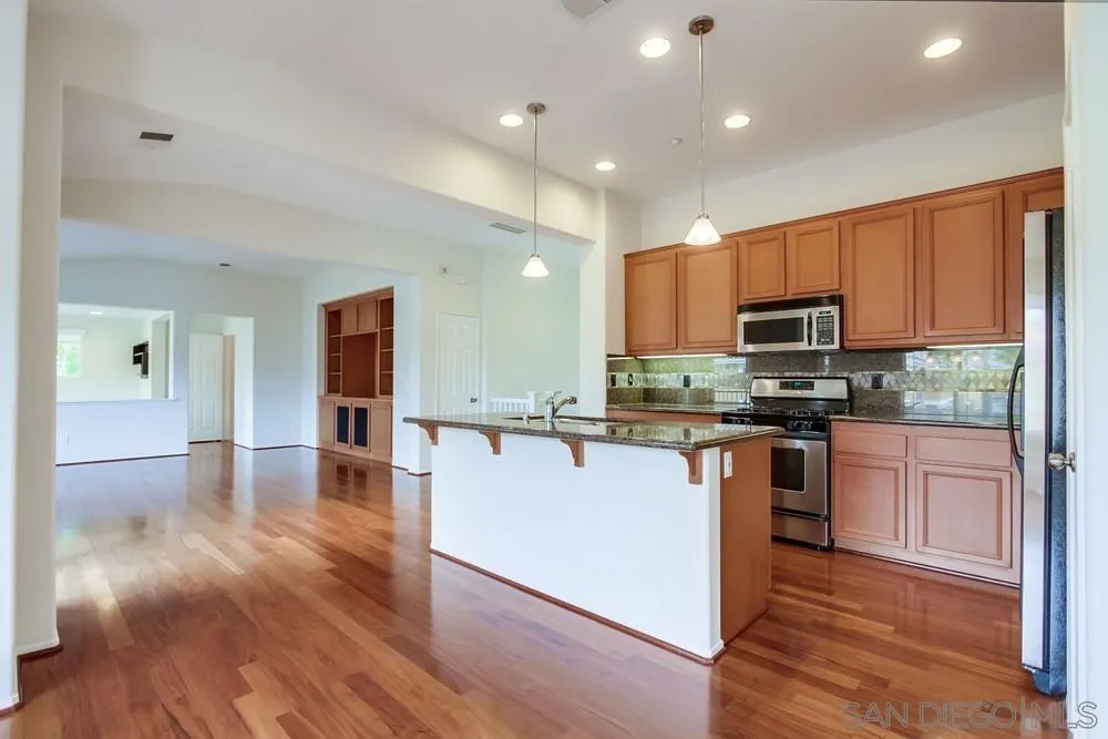 1631 Avery Road San Marcos, CA 92078 - Photo 13 of 32 a kitchen with stainless steel appliances granite countertop a refrigerator a stove top oven a sink and dishwasher with wooden floor