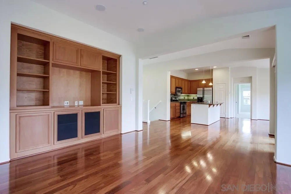 1631 Avery Road San Marcos, CA 92078 - Photo 9 of 32 a view of an empty room with wooden floor and a kitchen